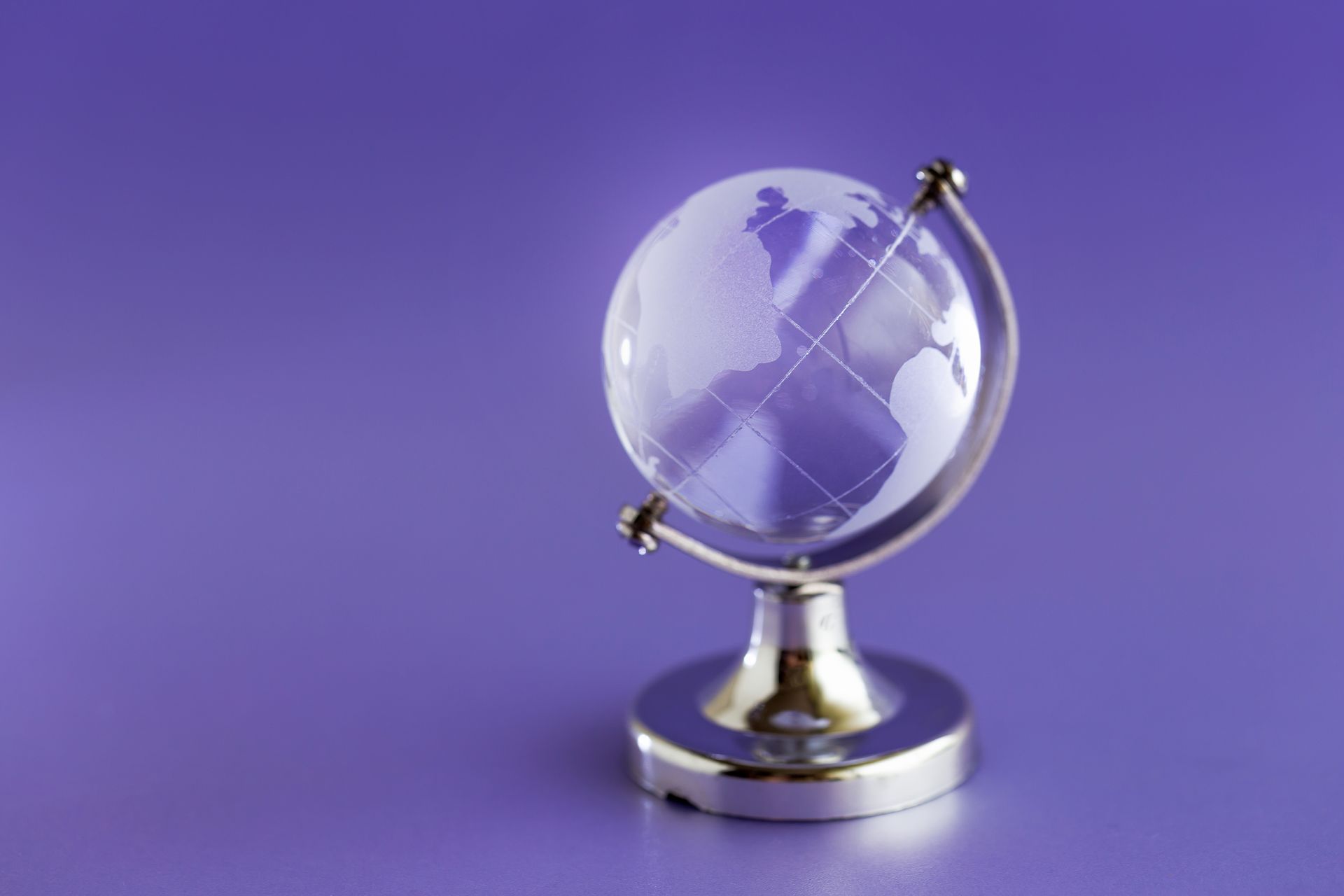 A small glass globe on a purple background.