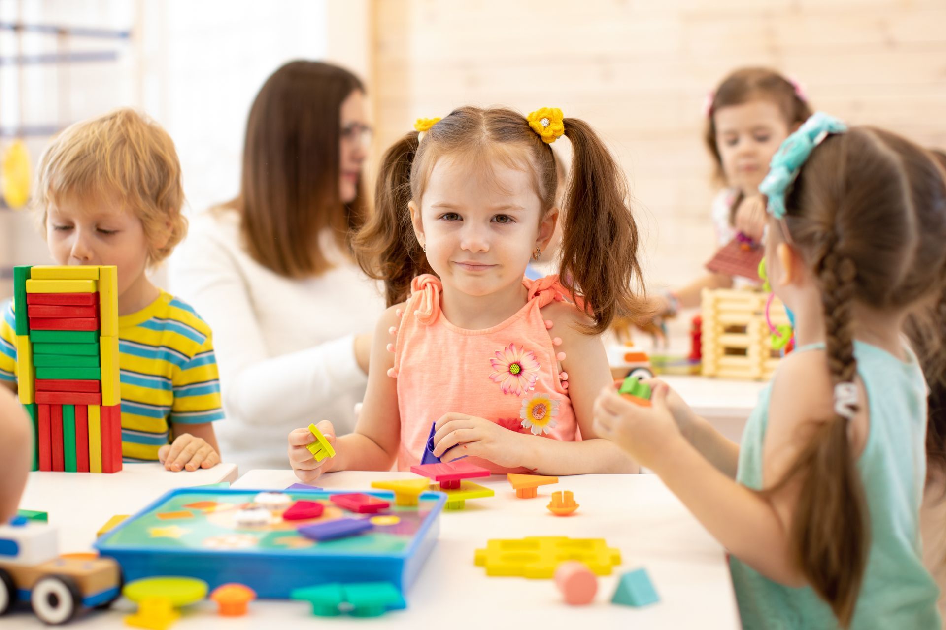 Group of preschool children playing with colorful didactic toys at kindergarten.