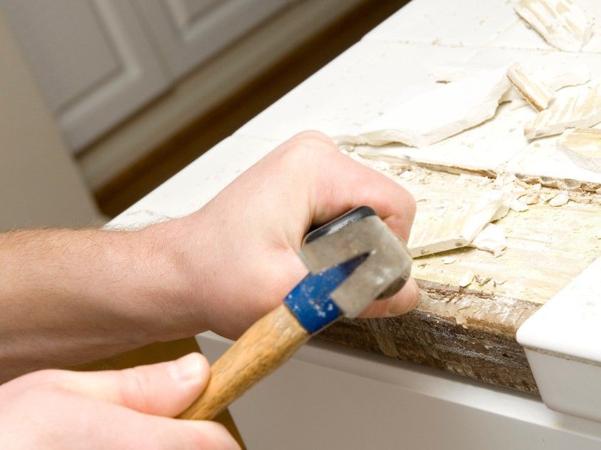 Derbyshire Tiling Specialists removing broken tiles from a kitchen in Derby before replacement