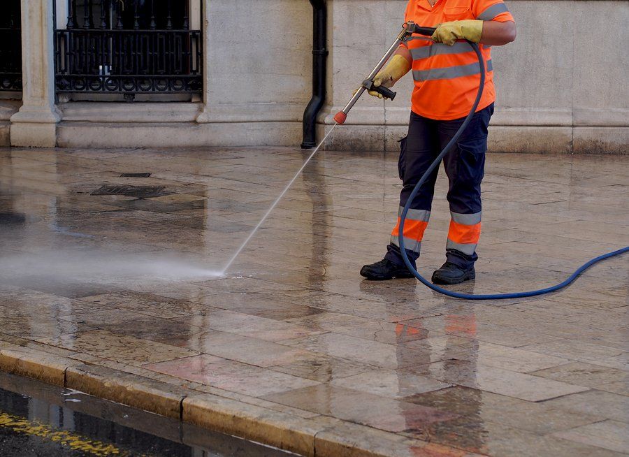 man spraying the driveway