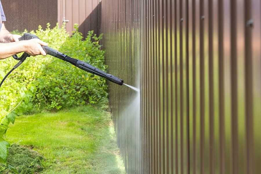worker spraying the fence