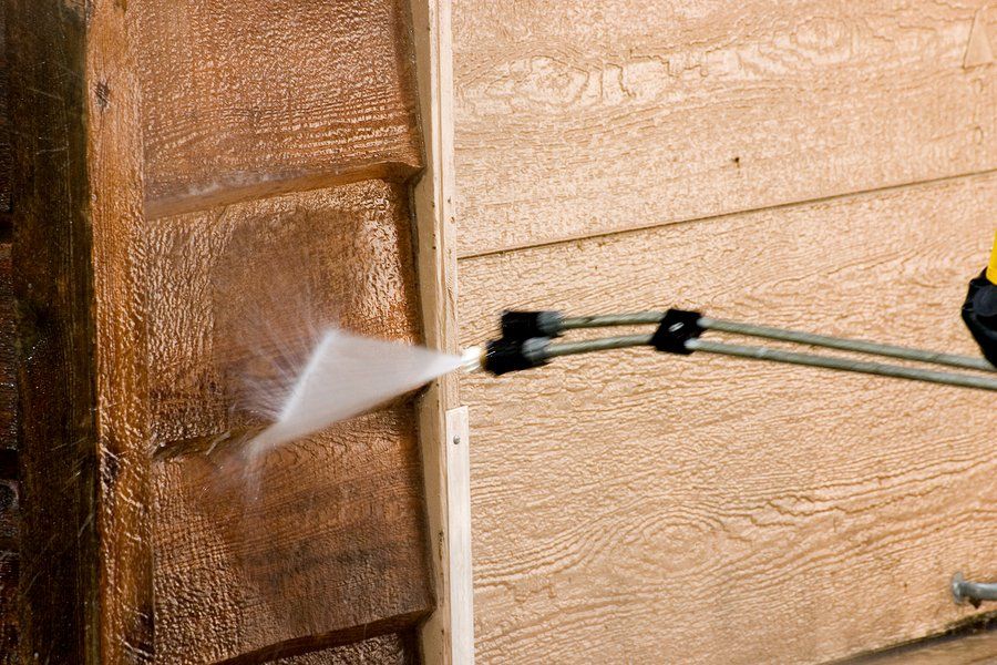 worker cleaning the wood fence