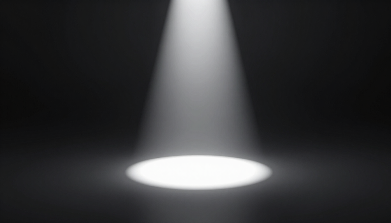 Bright white spotlight shining onto a dark stage floor, forming a glowing oval pool of light.