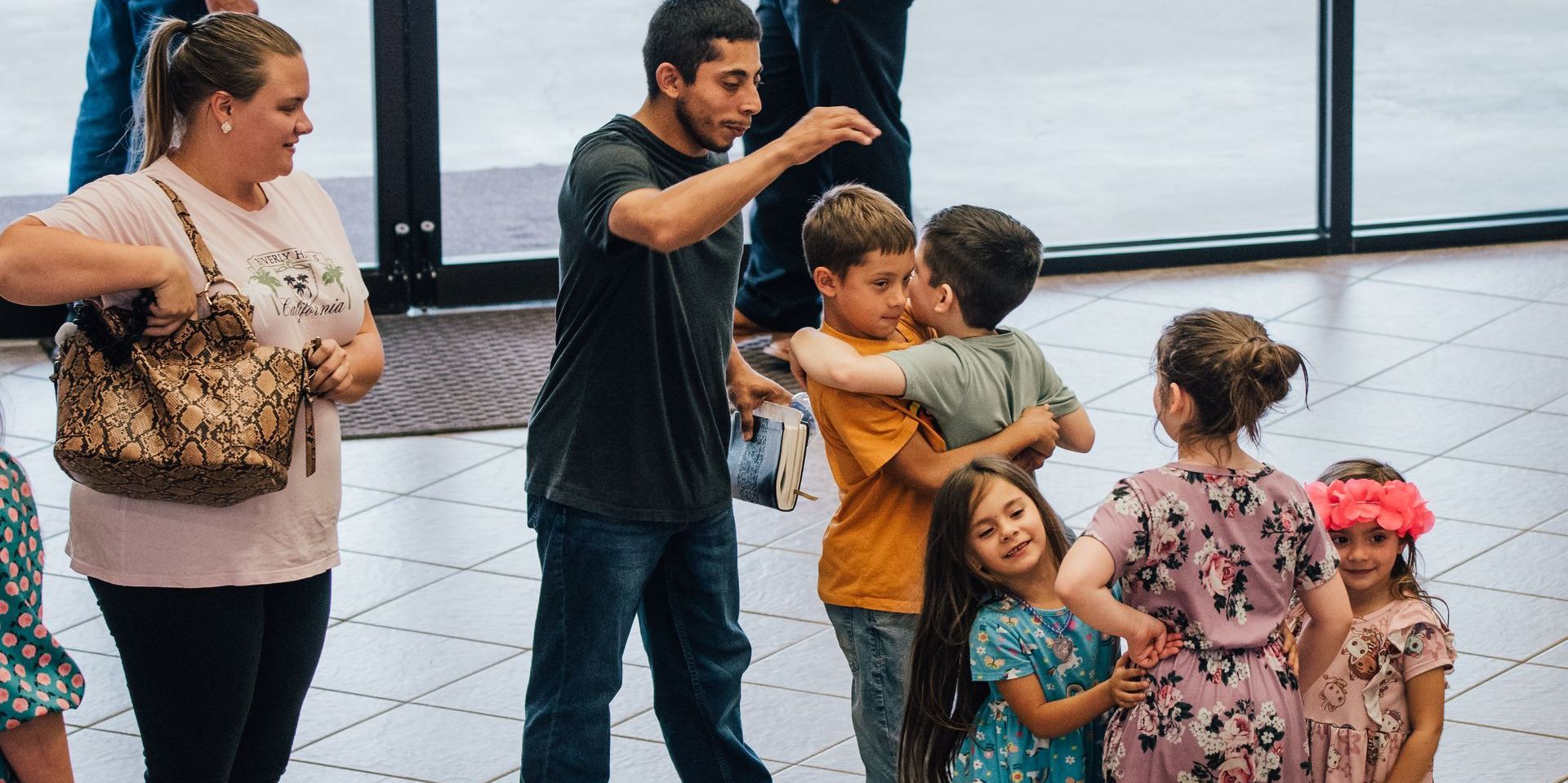 young family standing in foyer hugging