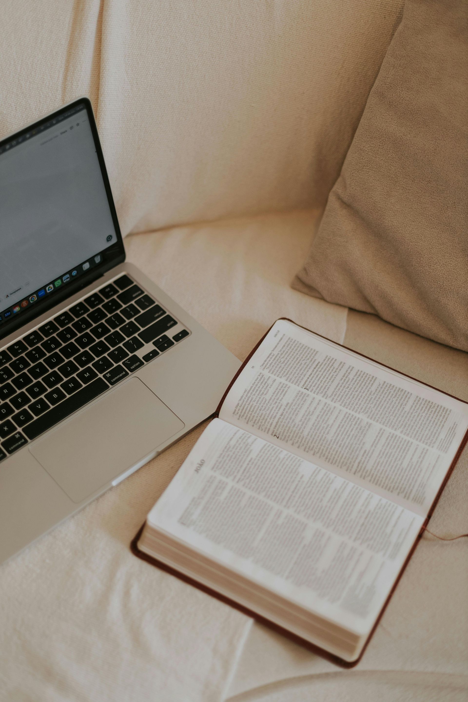 open bible in front of computer keyboard and screen