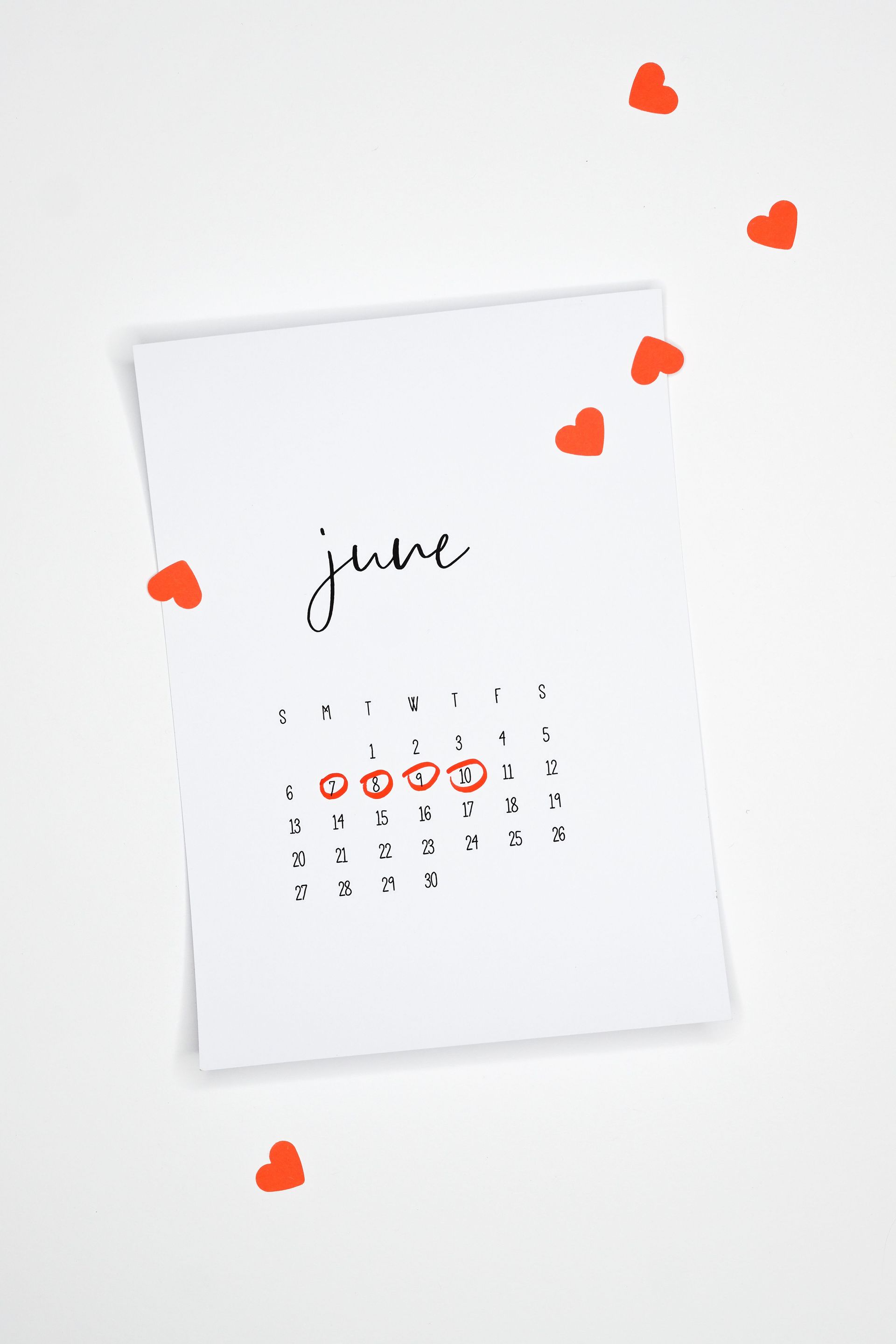 Minimal white June calendar page with orange heart decorations on a light background