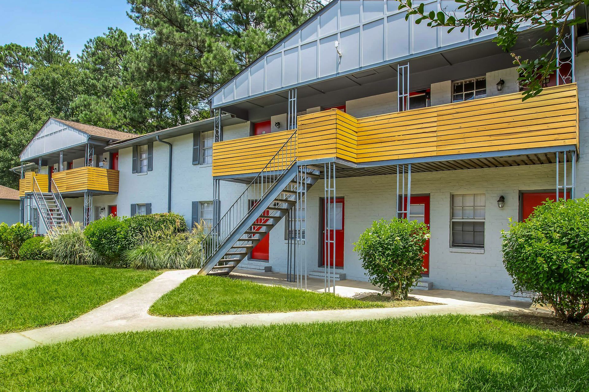 Apartment buildings on a grassy hill. Blue door stands out. Overcast sky.