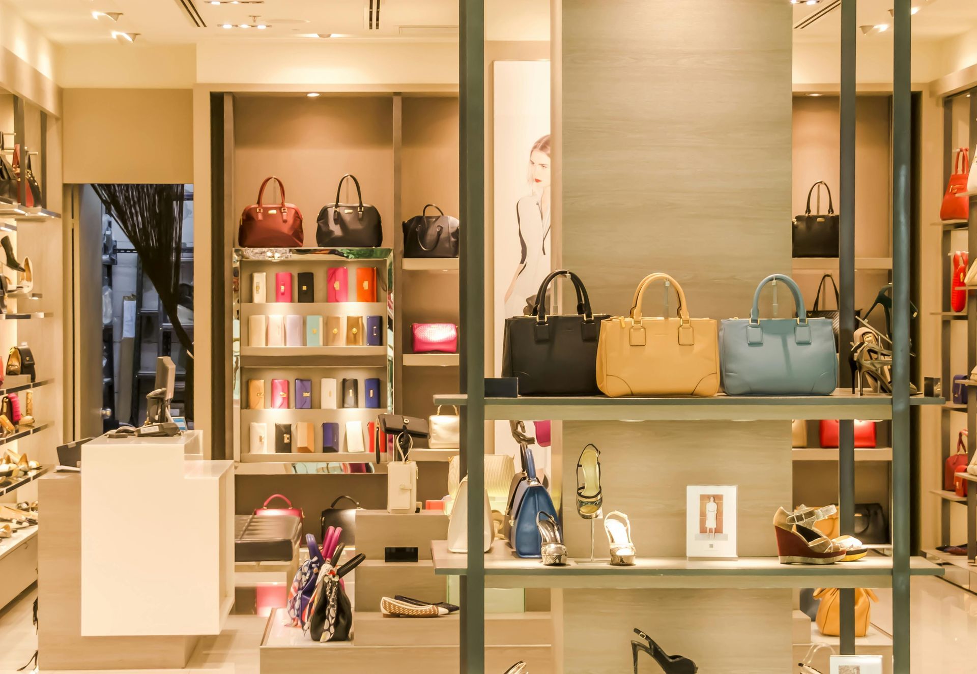 Vitrine de boutique de luxo com bolsas, frascos de perfume e acessórios em prateleiras iluminadas.
