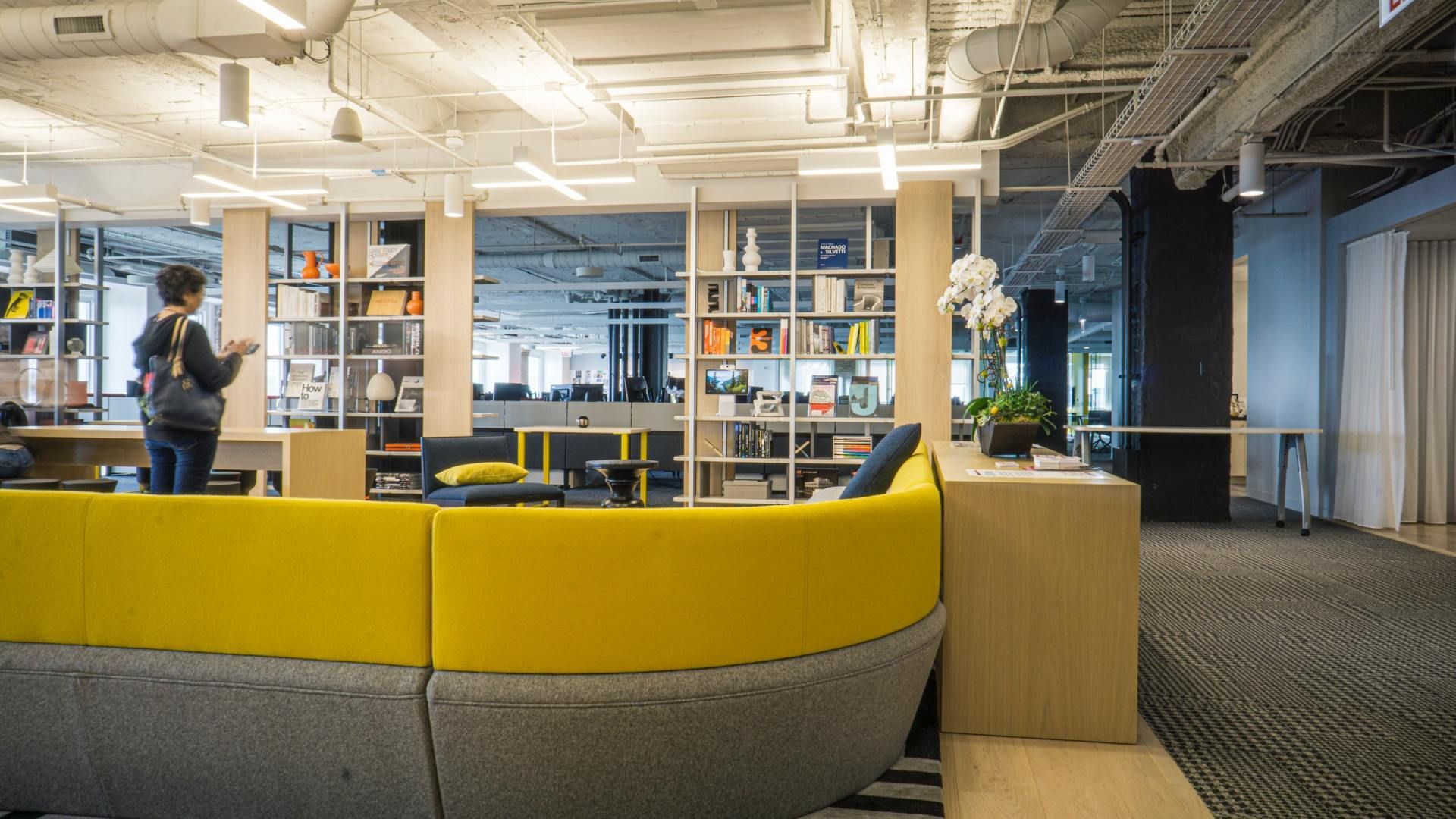 a person standing in a room with a yellow couch