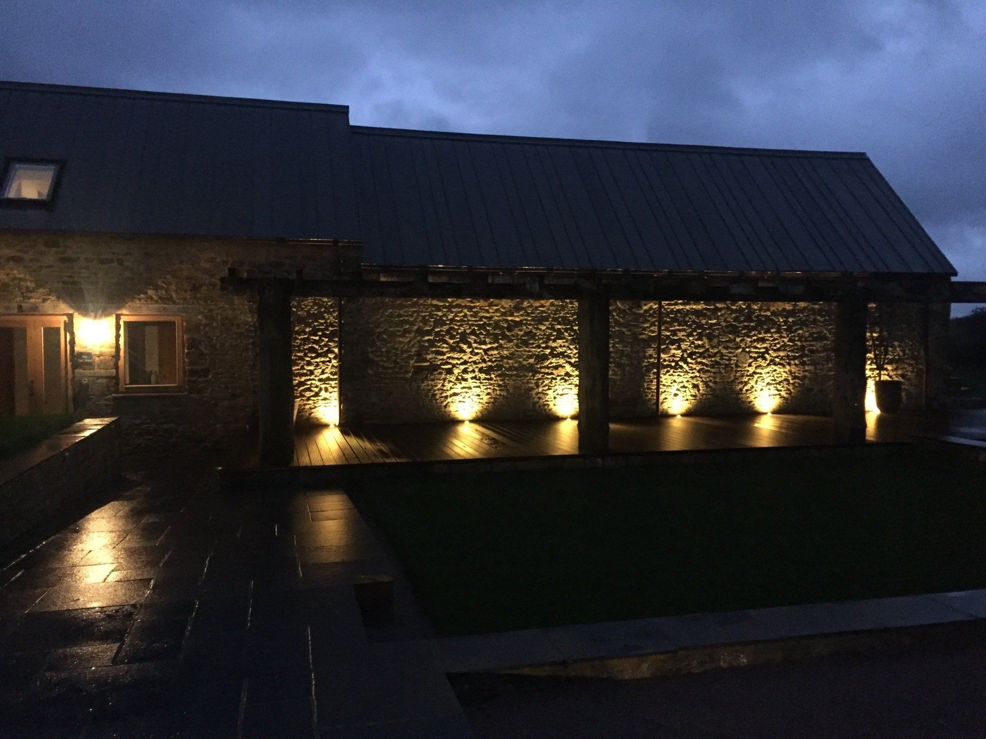 A stone building with lights on the side of it