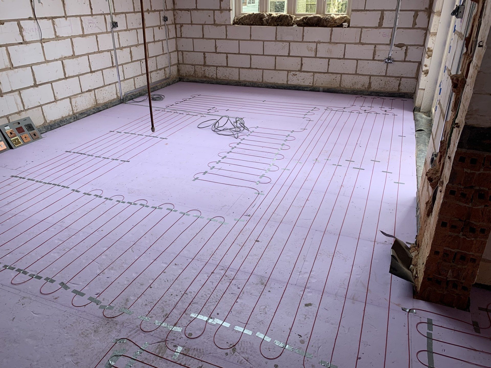A room with a purple floor and white brick walls