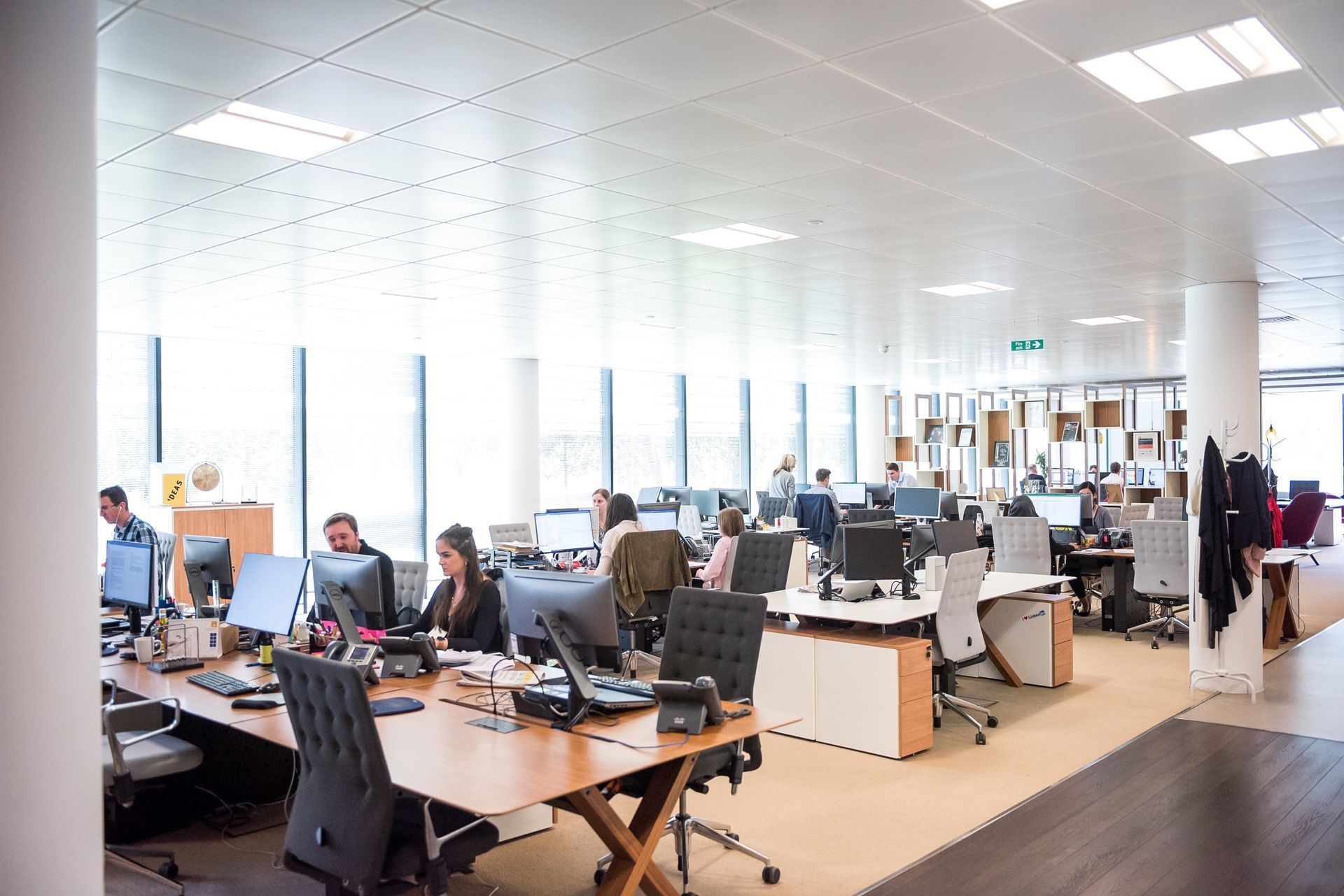 A group of people are sitting at desks in an office