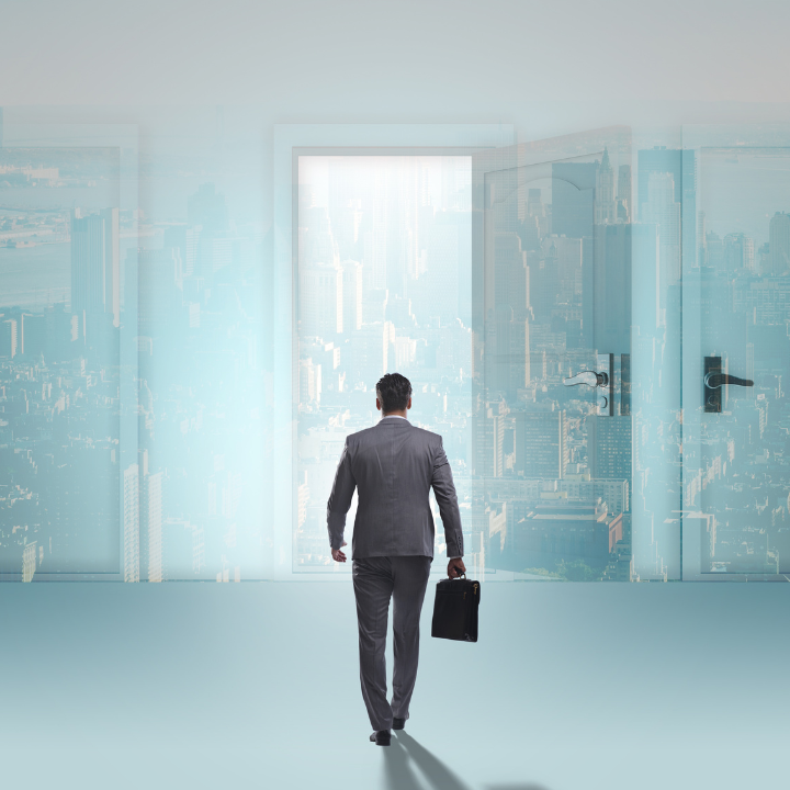 A man in a suit is walking through a door holding a briefcase.