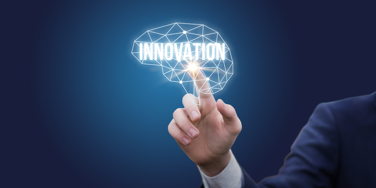 A man is pointing at a brain with the word innovation written on it.