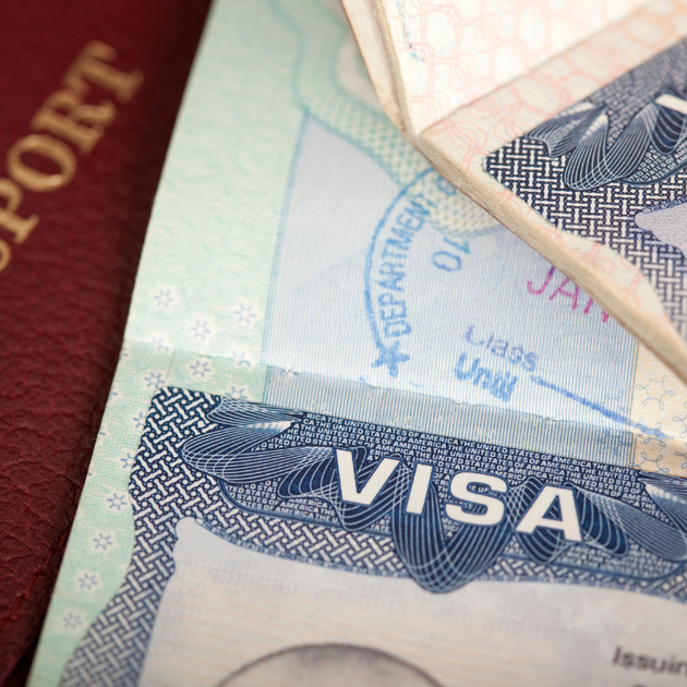 A close up of a visa next to a passport