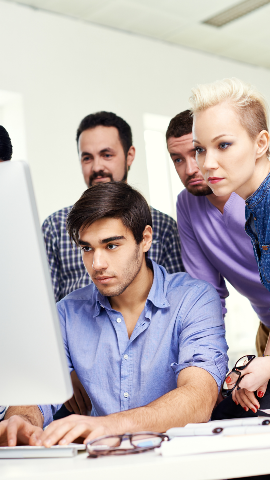 A group of people are looking at a computer screen.