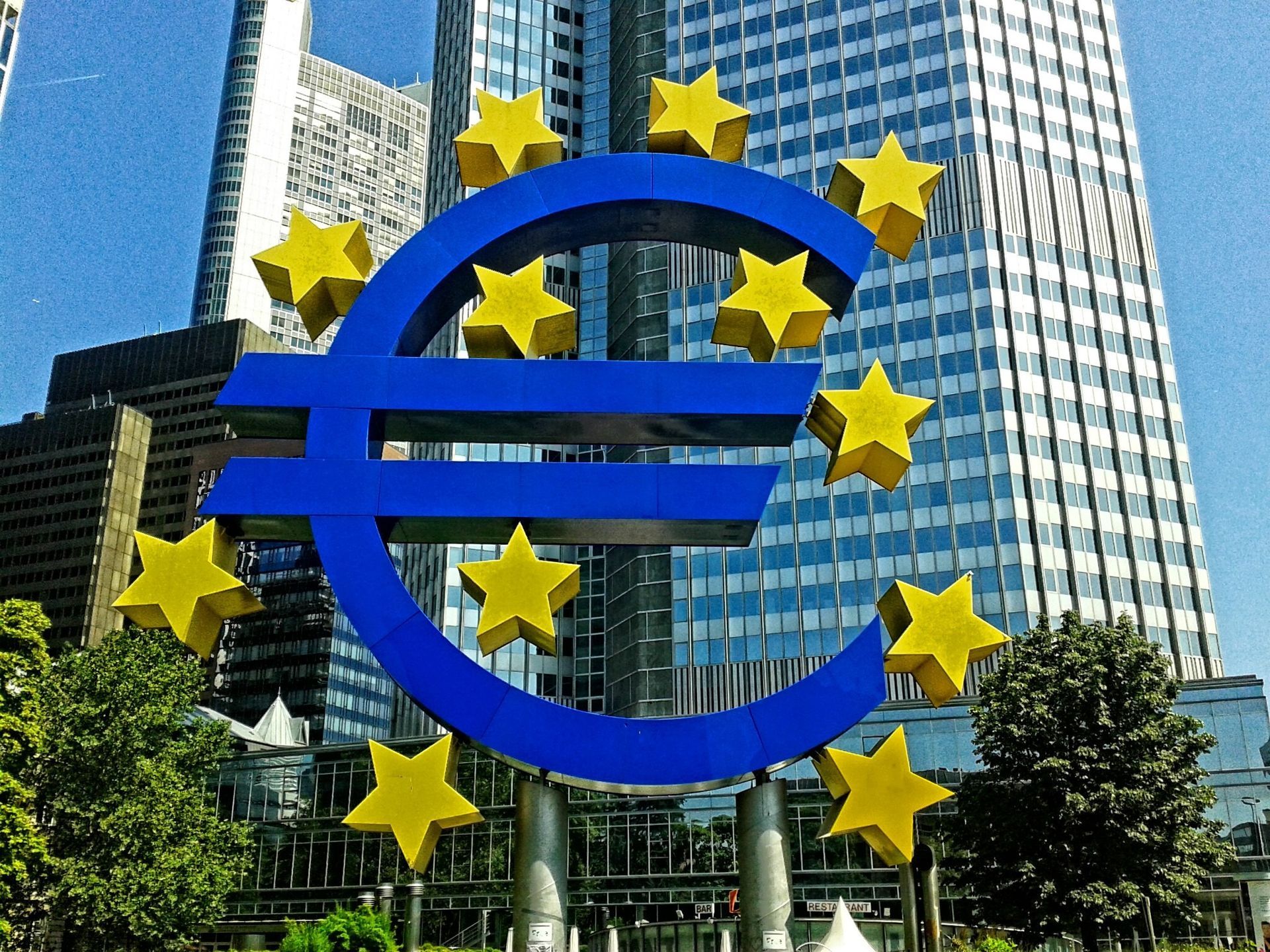 A large blue euro sign with yellow stars around it