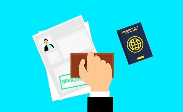 A hand is stamping an approval stamp on a passport.
