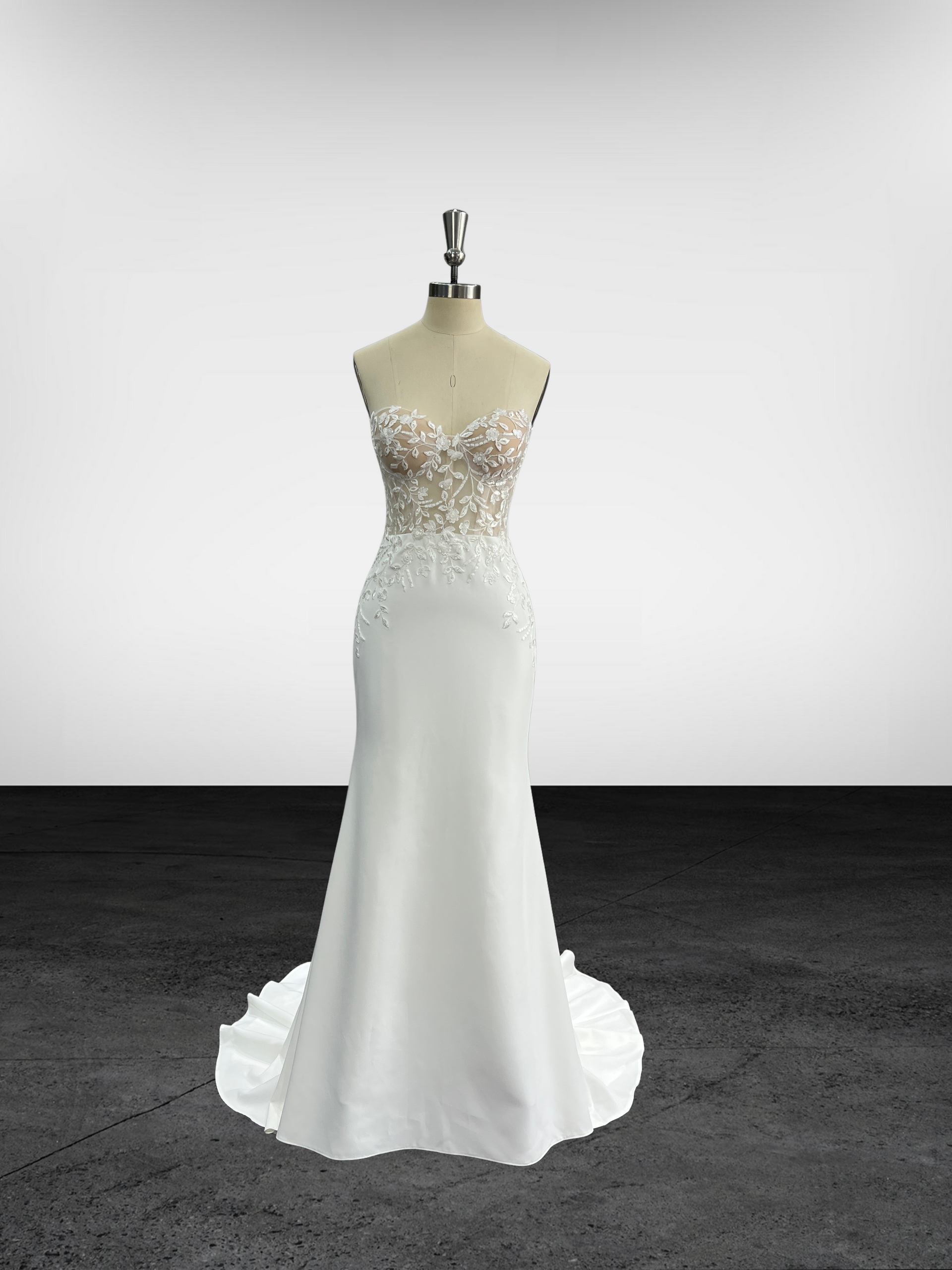 Une robe de mariée blanche est sur un mannequin dans une pièce