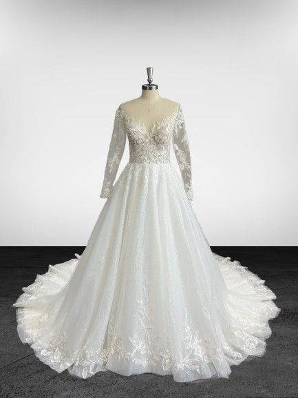 Une robe de mariée blanche à manches longues est sur un mannequin.
