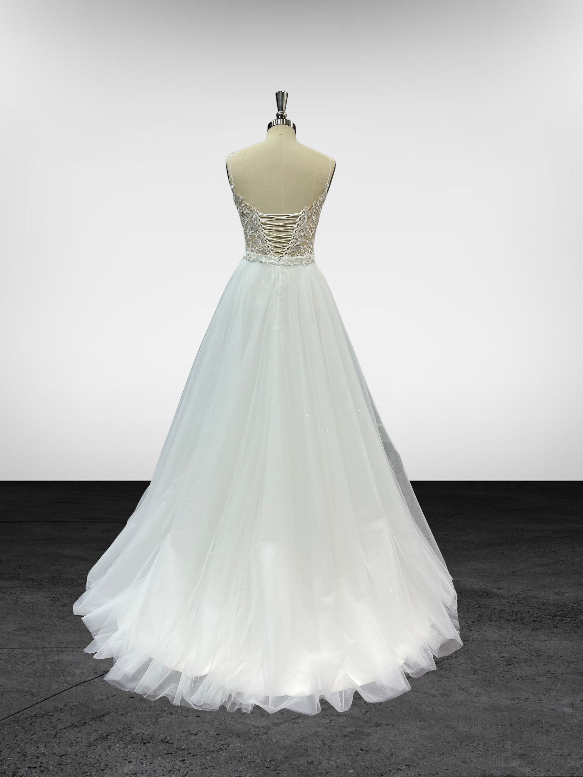 Une robe blanche est sur un mannequin dans une pièce.