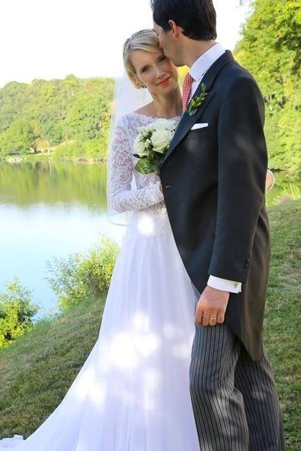 Une mariée et un marié s'embrassant devant un lac