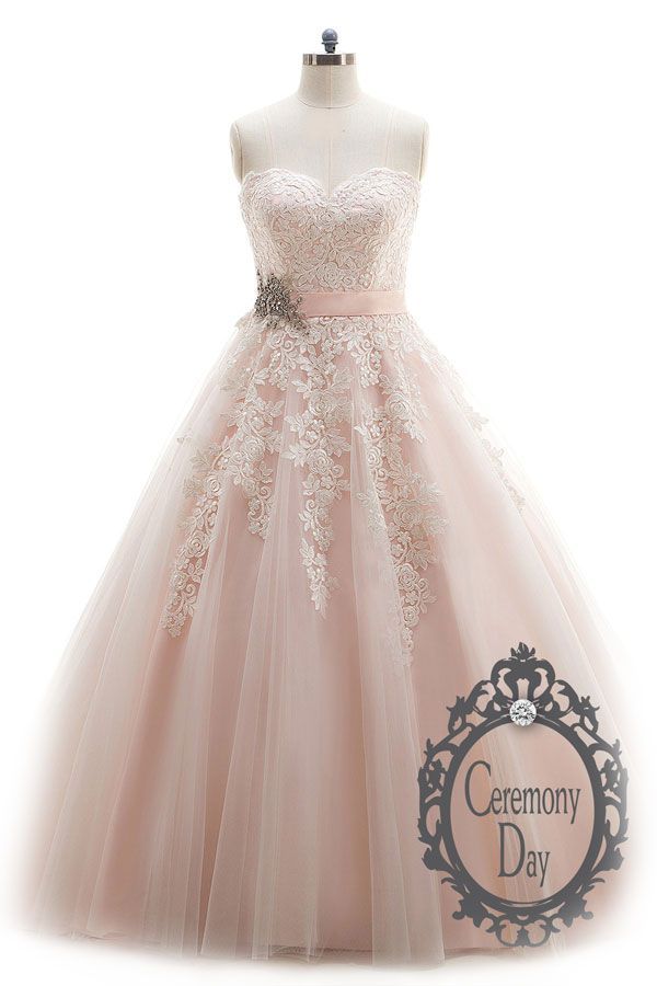 Une robe de bal rose est sur un mannequin sur fond blanc.