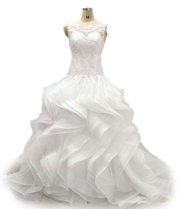 Une robe de mariée blanche est sur un mannequin sur fond blanc.