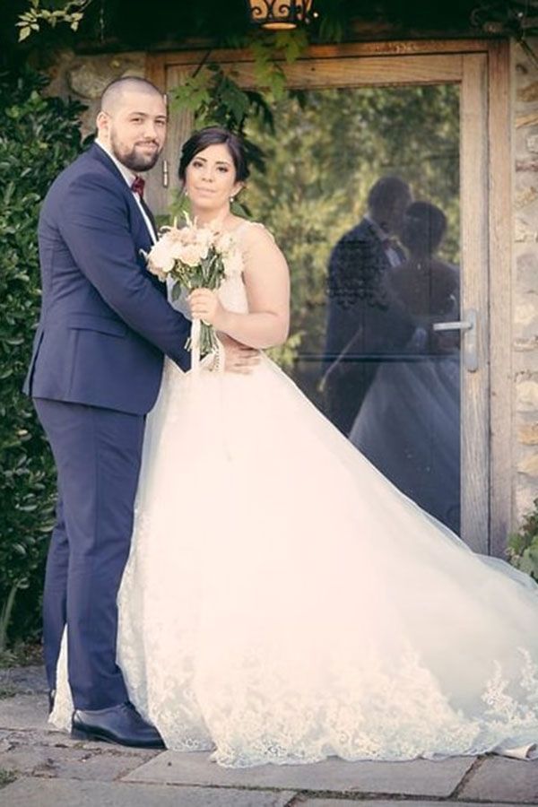 Une mariée et un marié posent pour une photo devant une porte.