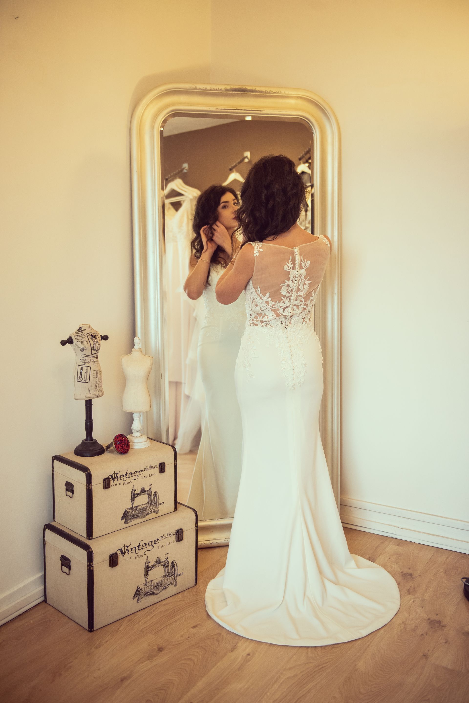 Une femme en robe de mariée se regarde dans un miroir.