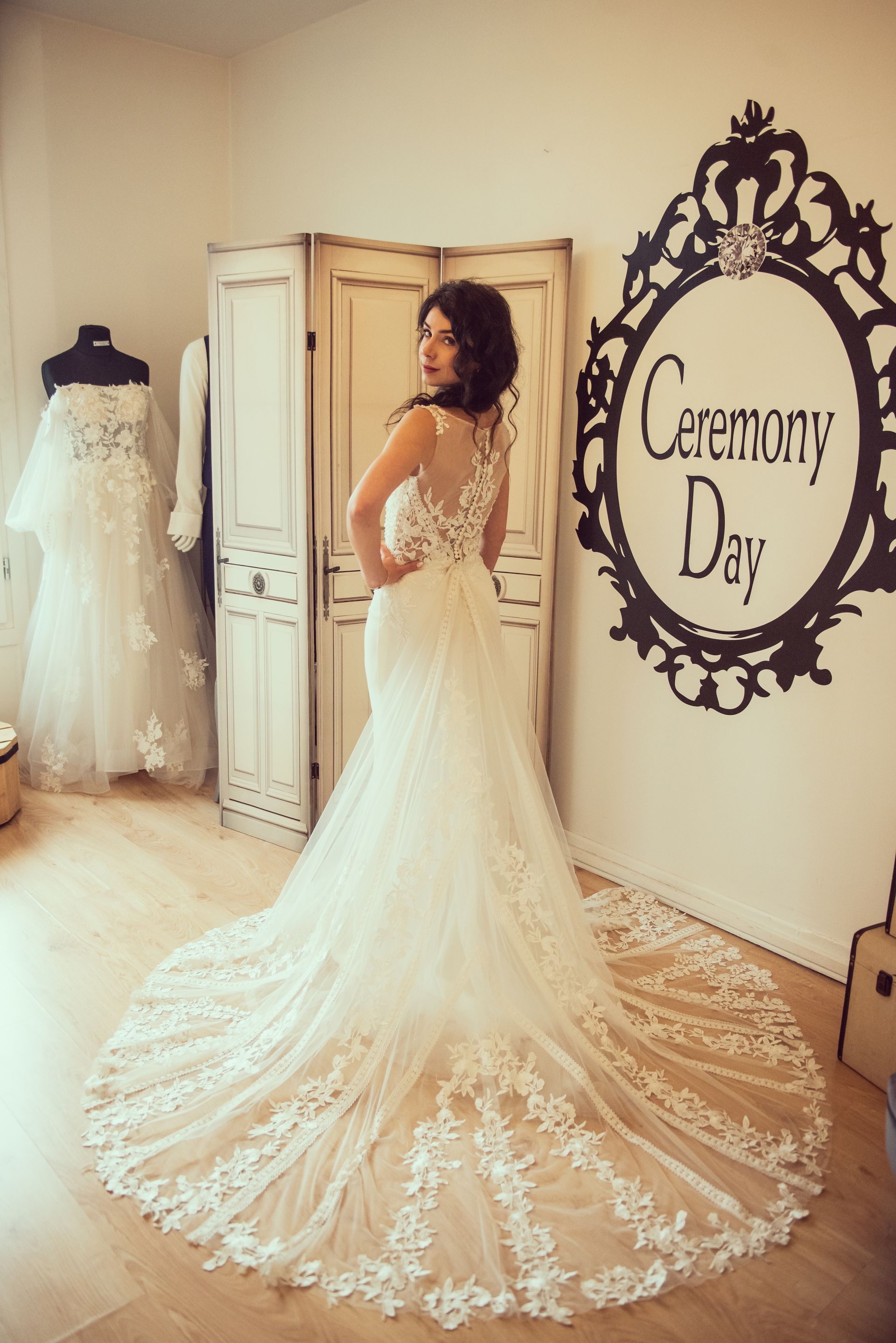 Une femme en robe de mariée se tient devant un miroir.