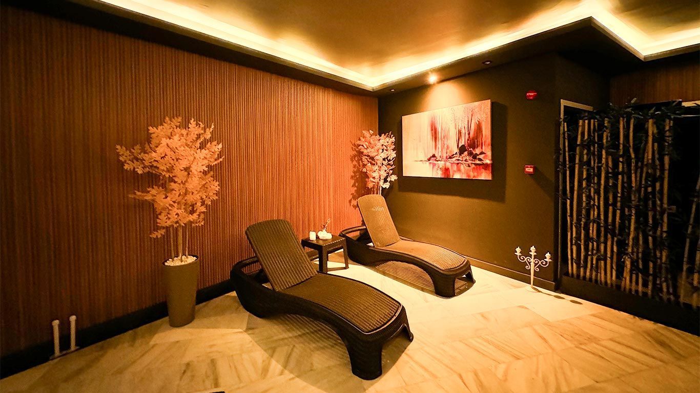 Duvarında bir tablo bulunan bir odada iki şezlong bulunmaktadır. Aldino Hotel Ankara, Spa