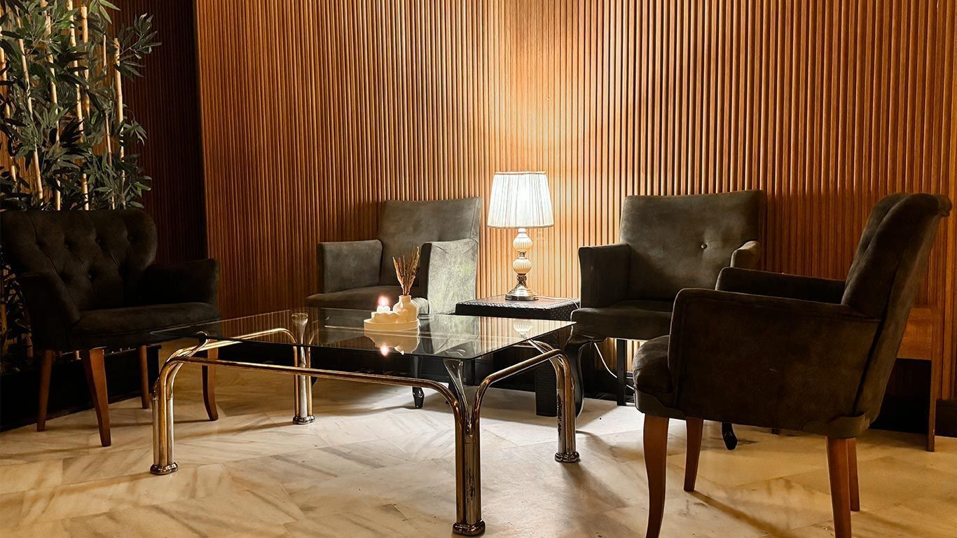 A Spa room with chairs , a table and a lamp | Aldino Hotel