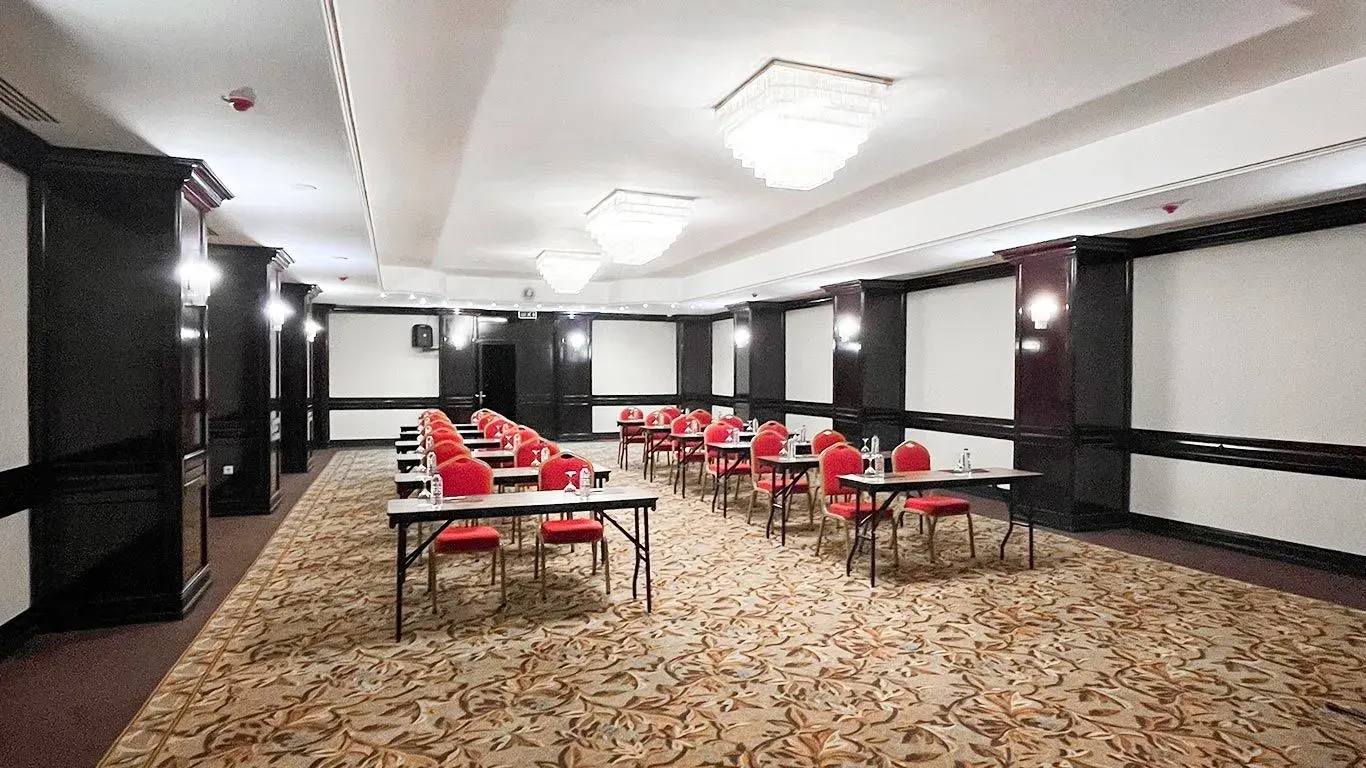 İçinde masa ve sandalyeler bulunan büyük bir toplantı odası | Aldino Hotel