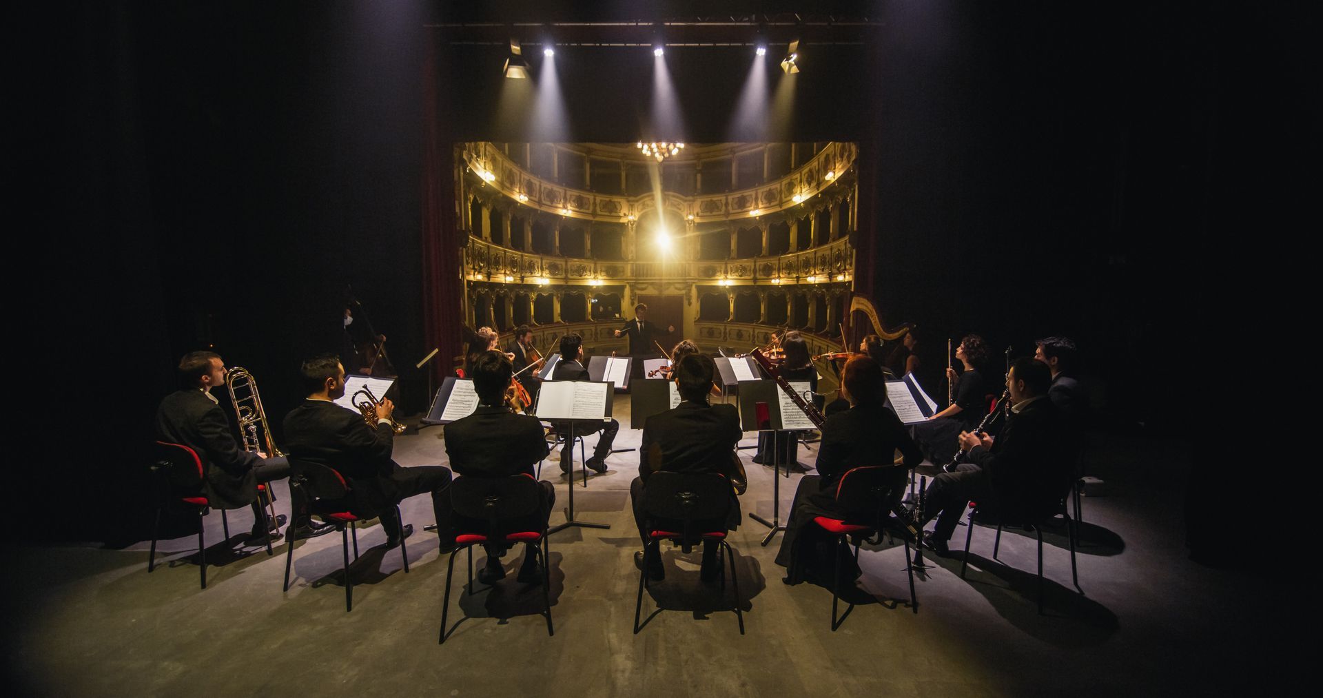 A large orchestra is playing on a stage in a theater.