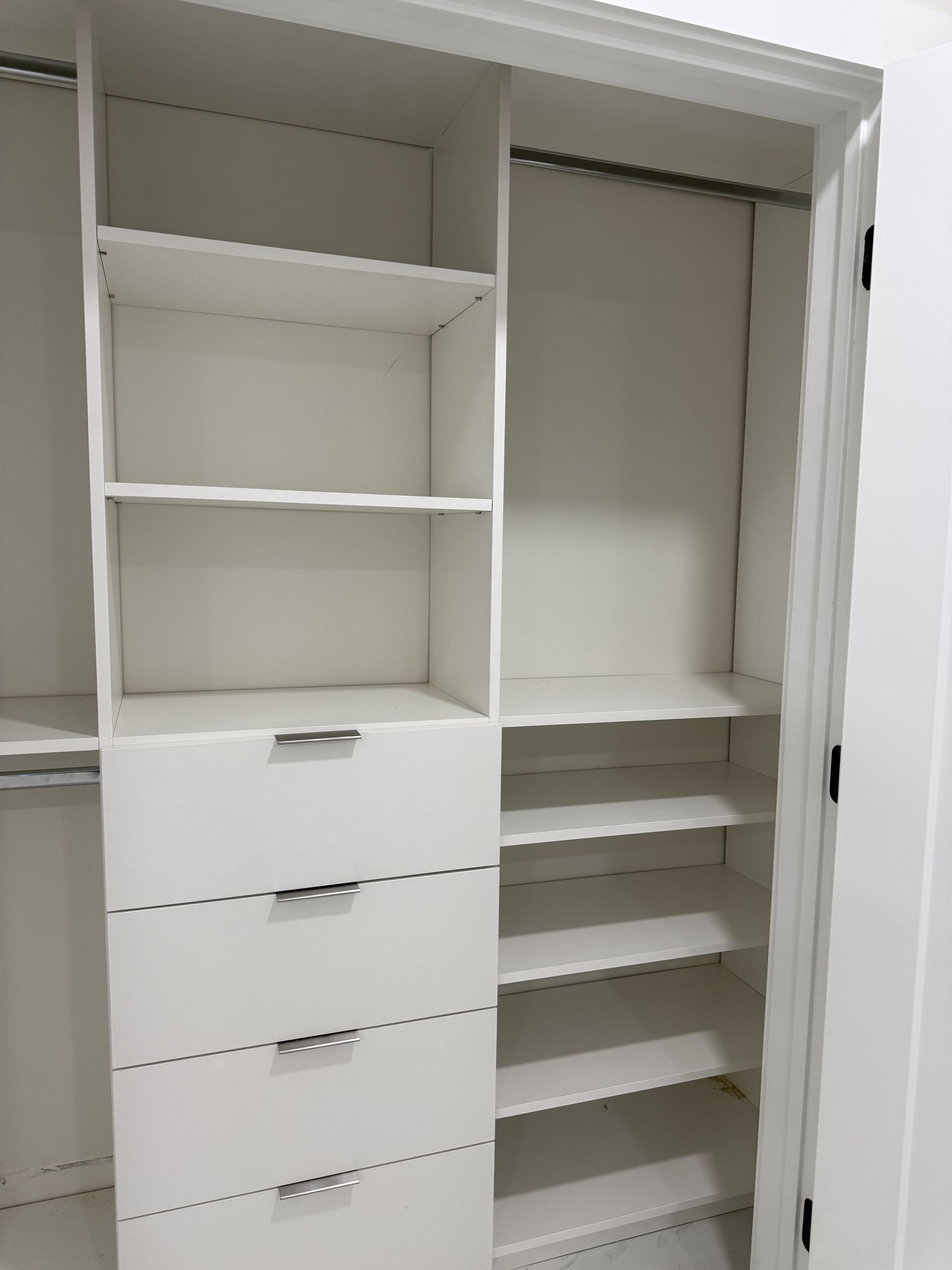White closet with shelves, drawers, and hanging rod.