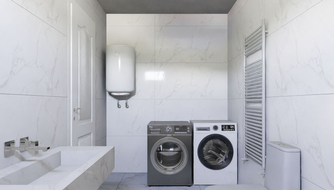 Small white laundry room with washer, dryer, sink, wall cabinet, and radiator.