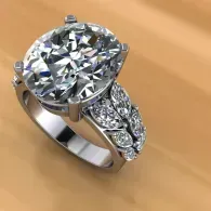 Large round diamond engagement ring with a silver band and smaller side stones on a tan background