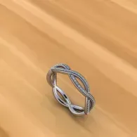 Silver twisted ring on a light wooden surface