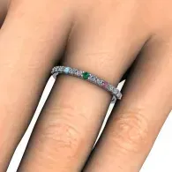 Hand with a thin silver ring set with colorful gemstones on a finger
