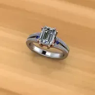 Silver ring with a rectangular emerald-cut gemstone on a wooden surface