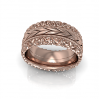 Rose gold ornate ring with engraved floral swirl patterns on a white background