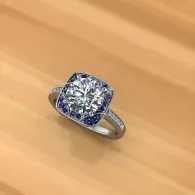 Silver ring with a square blue-and-white gemstone on a wooden surface