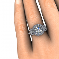 Close-up of a hand wearing a silver diamond engagement ring with a halo setting