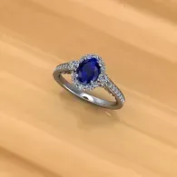 Silver ring with a blue oval gemstone on a wooden surface