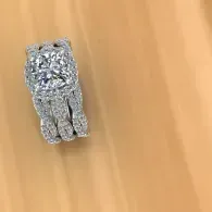 Small silver diamond ring on a light wooden surface