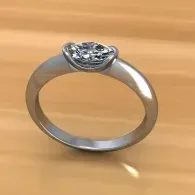 Silver ring with a diamond solitaire on a wooden surface
