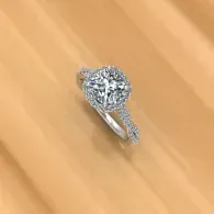 Silver ring with a large round diamond on a light wooden surface