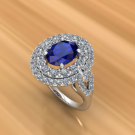 Silver ring with a blue gemstone and diamond halo on a warm gold background