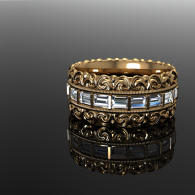 Gold and silver jeweled ring with blue stones on a reflective black surface
